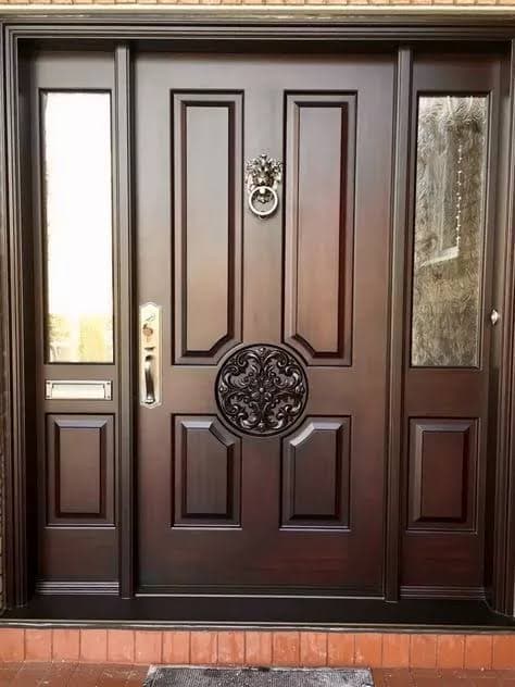 Classic carved dark wood double entrance door with decorative brass knocker
