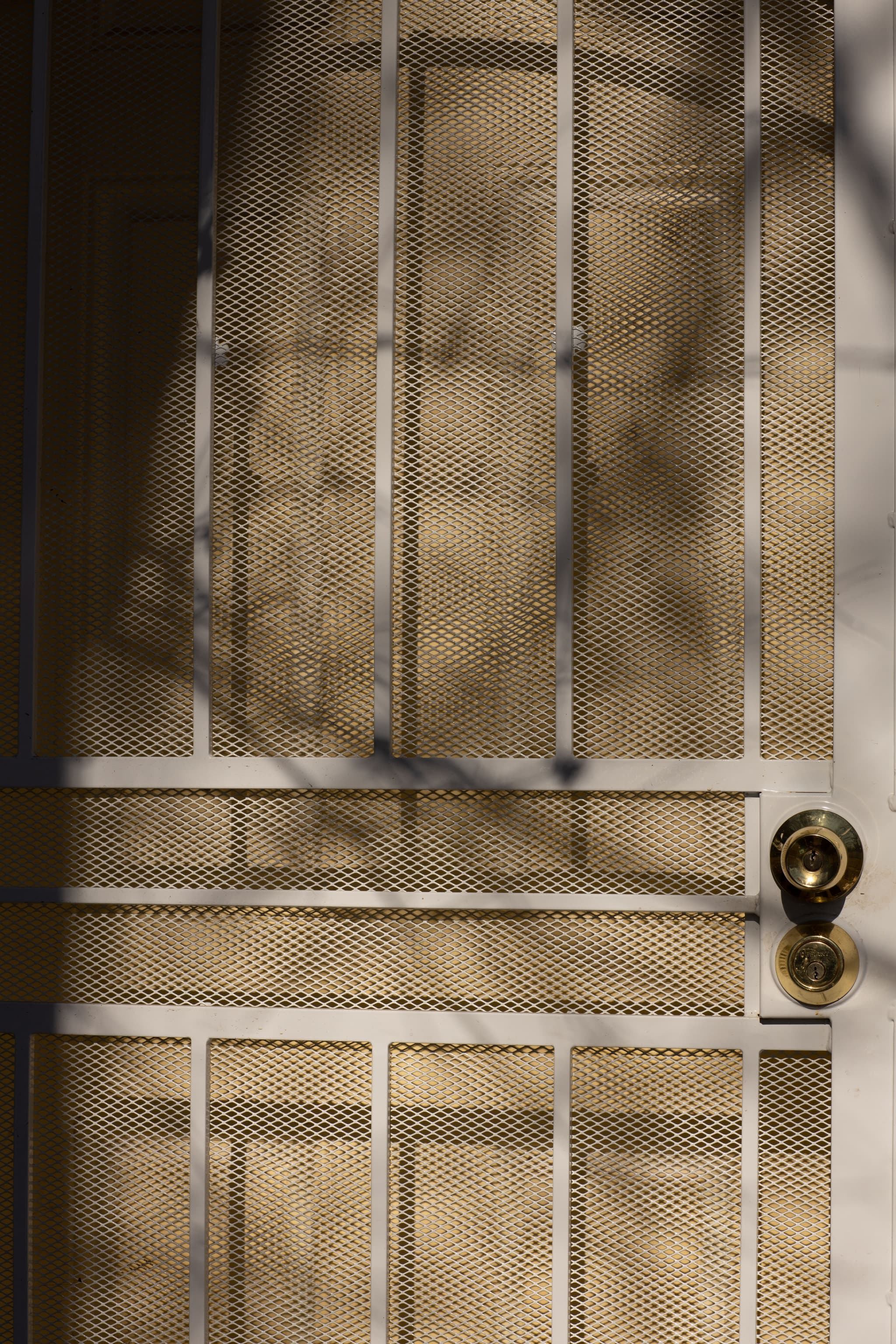 Ventilation mesh infill on a safety door, with the lock and deadbolt set into the stile