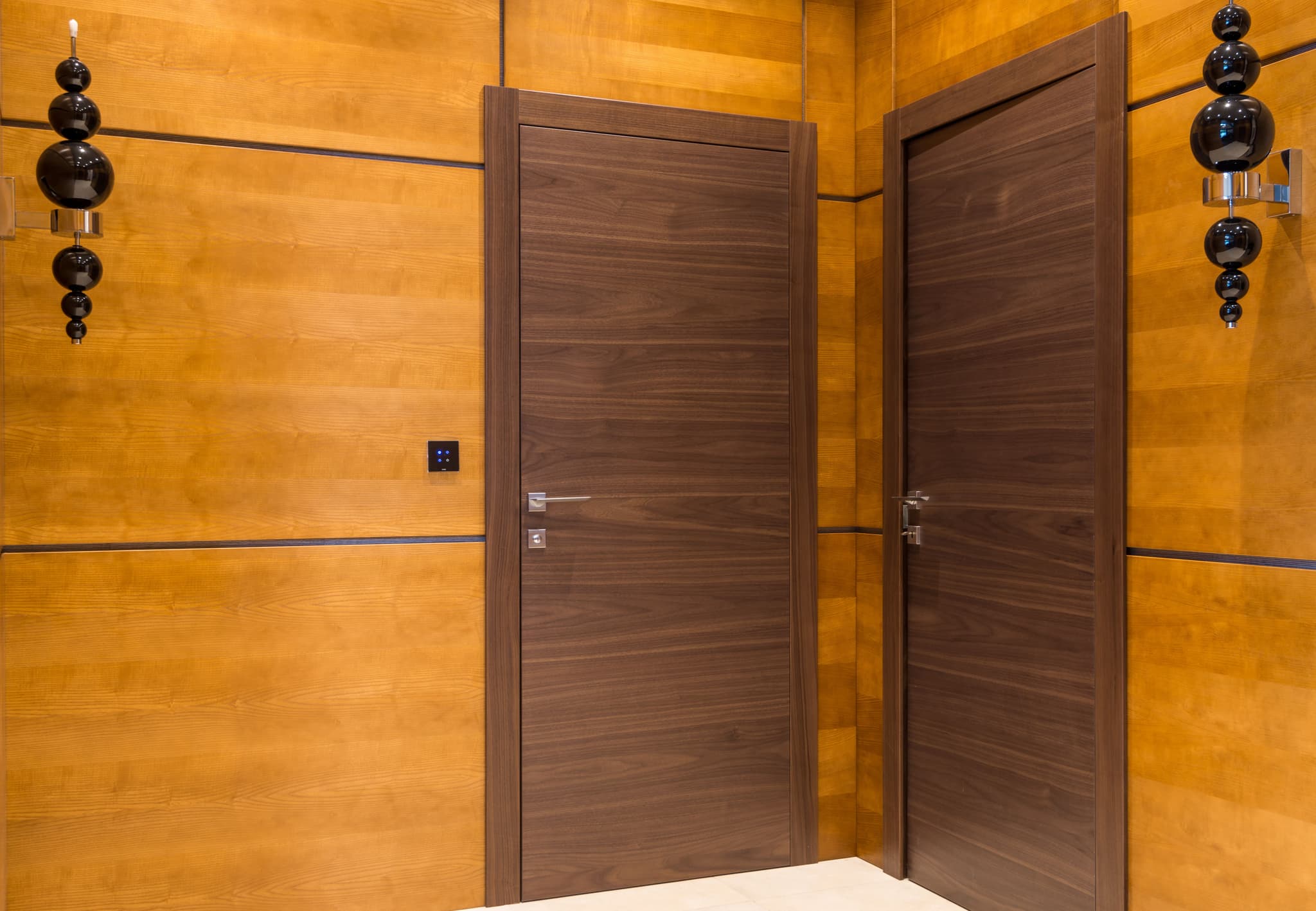 Wood veneer entrance doors and matching wall panelling with lever handles